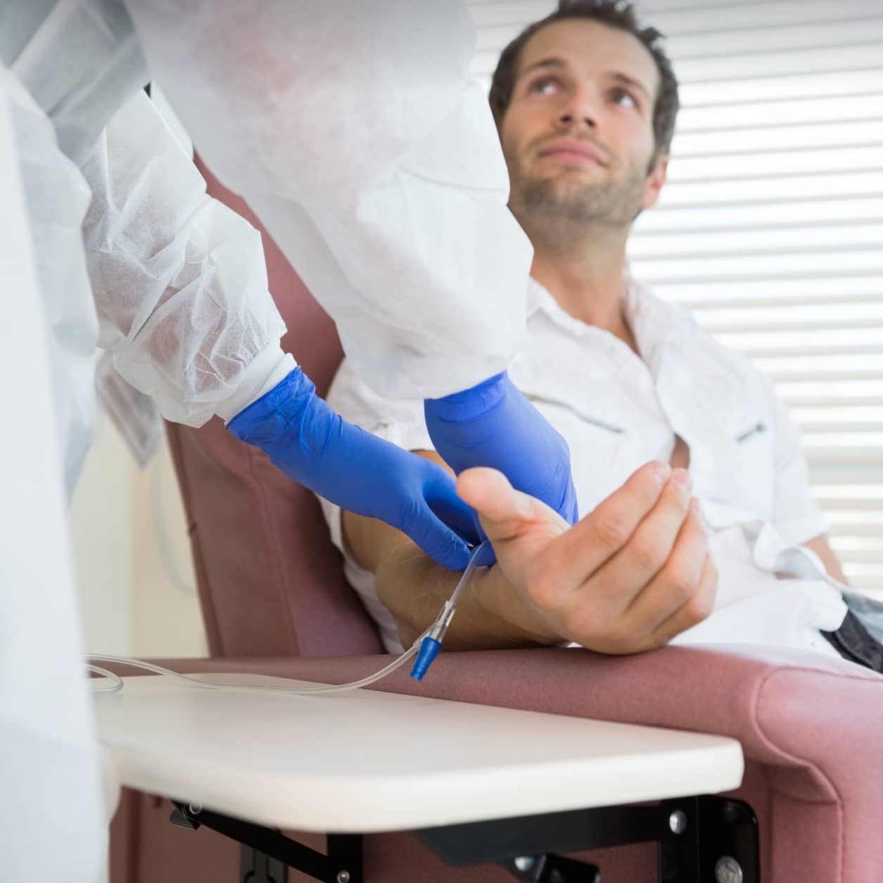 A practitioner helping a patient with infusion therapy.
