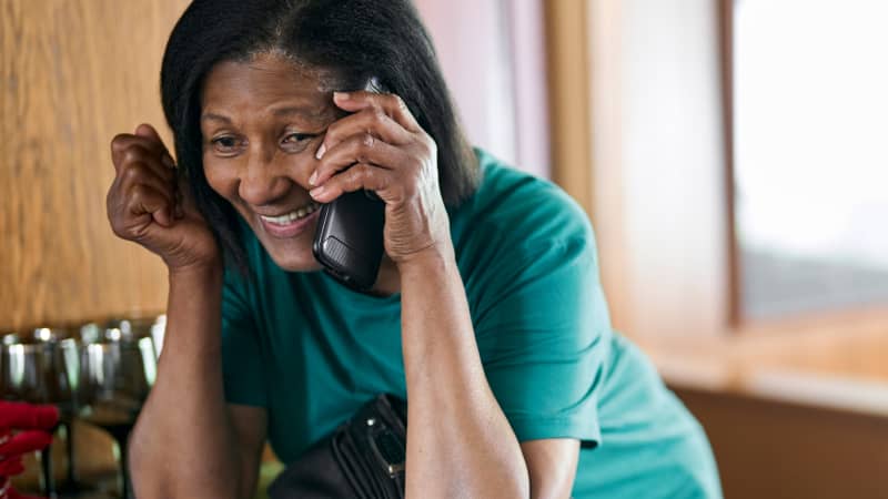 A person smiling while on their cellphone with their CareTeam.
