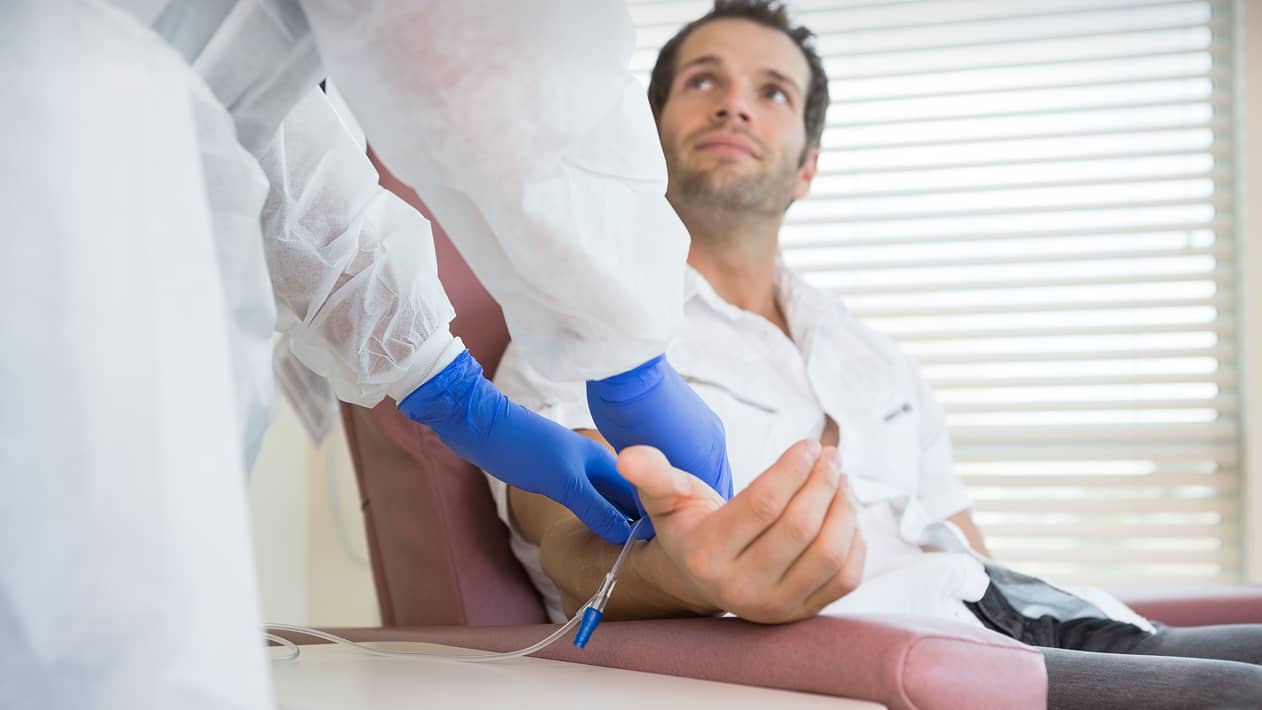 A practitioner helping a patient with infusion therapy.