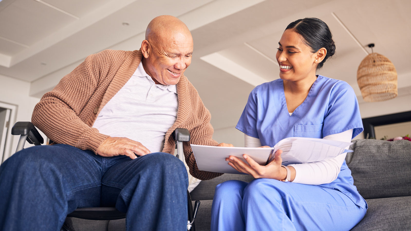 individual in wheelchair with nurse reading patient education material