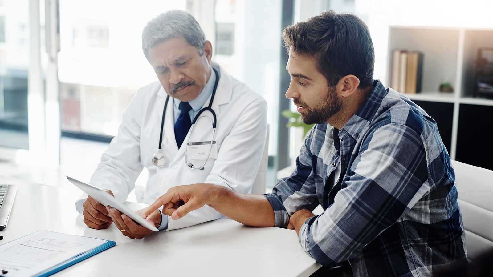 Doctor in discussion with a patient over a tablet.