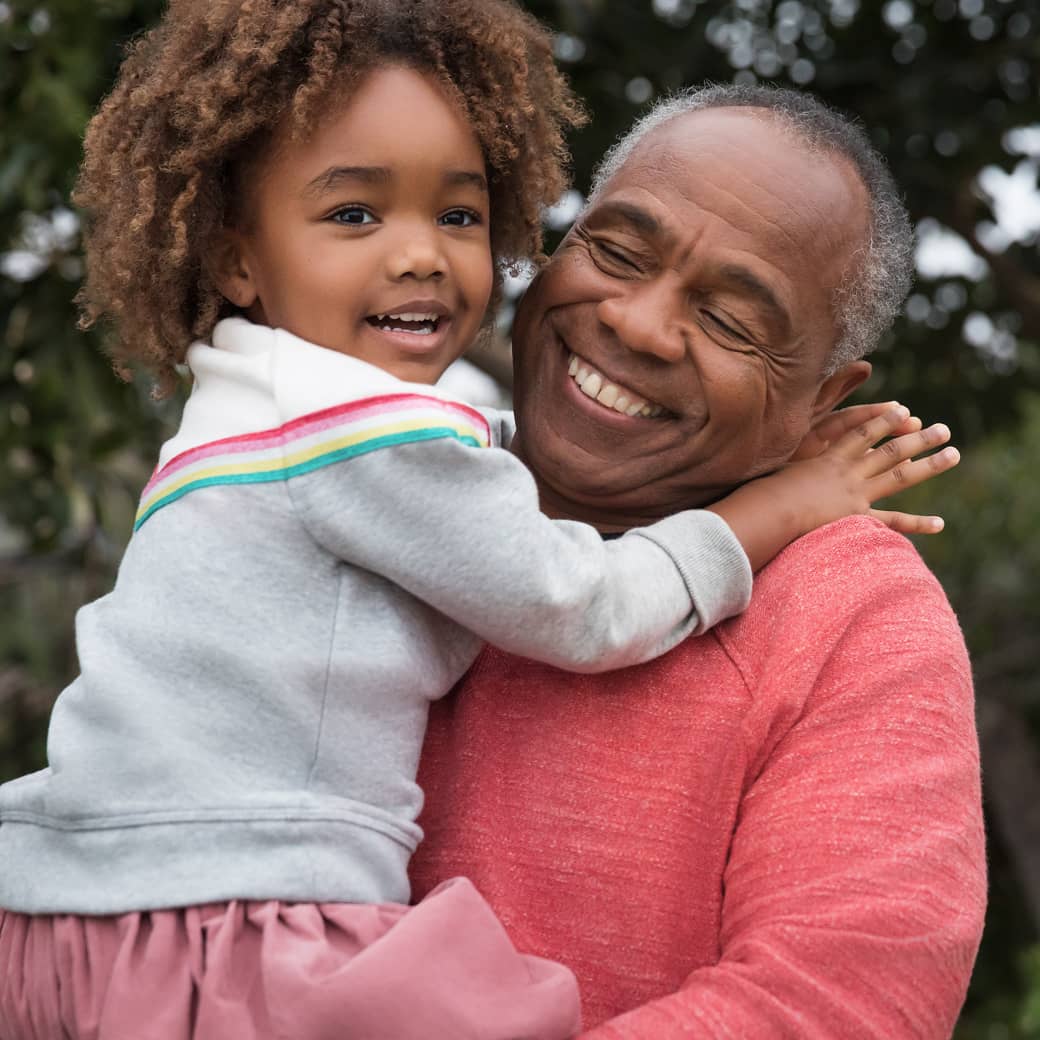 A grandparent holds their grandchild
