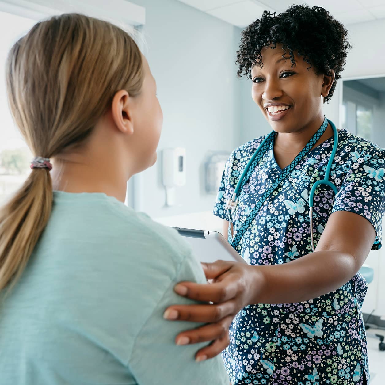 A health care provider in conversation with a patient in an exam room