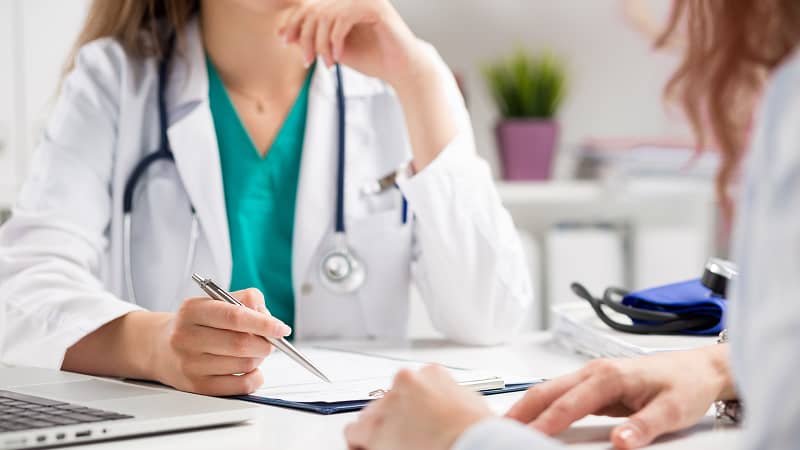 A practitioner making notes for a conversation with a patient.