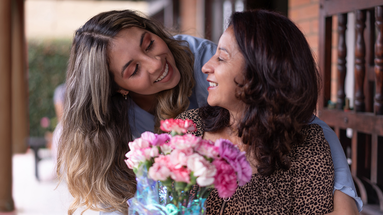 Two people sharing a moment, one holding flowers.