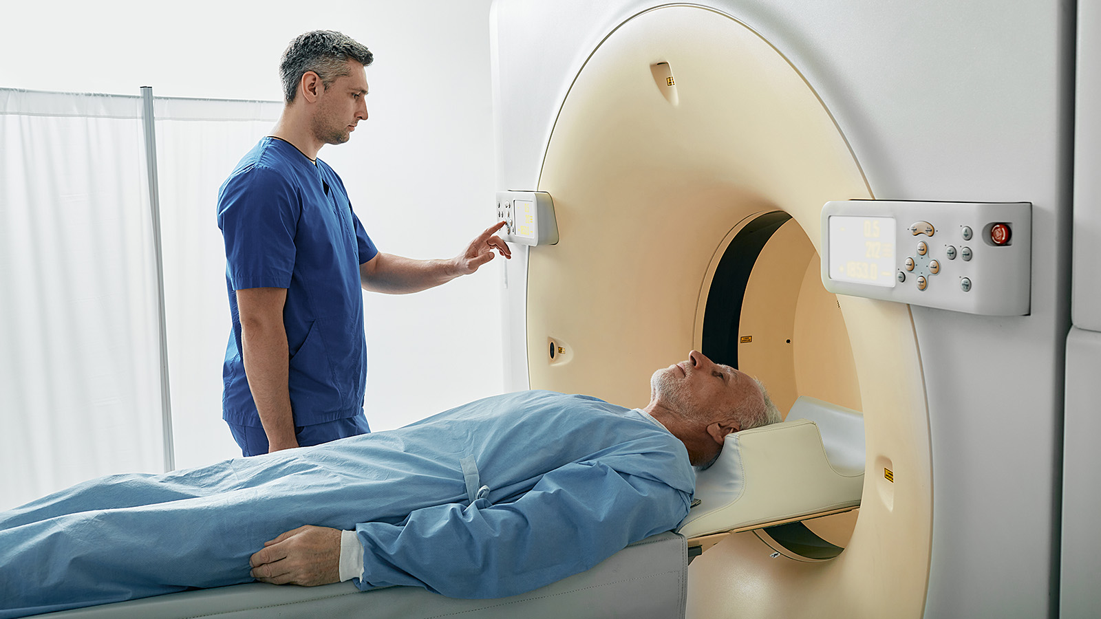 A medical professional operating a machine near a patient