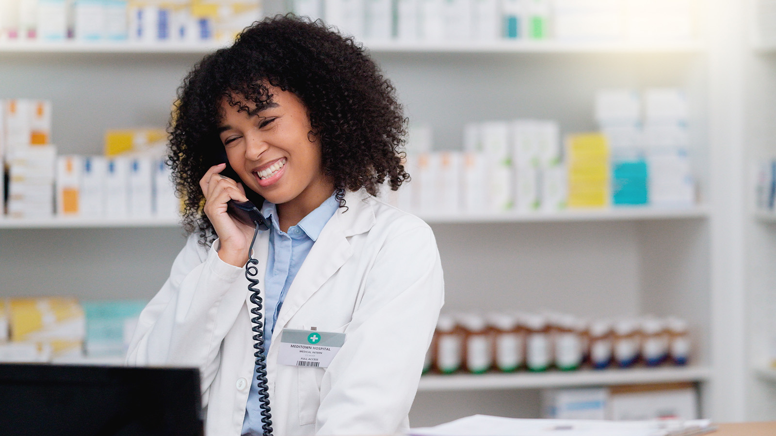 A pharmacist on the phone in a pharmacy