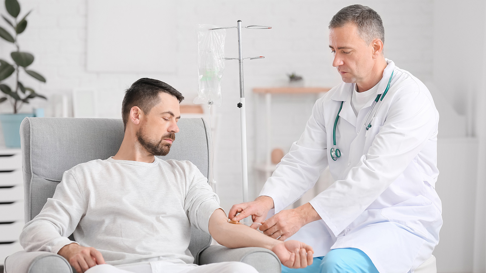 A healthcare provider administers treatment to a patient sitting in a chair, highlighting a supportive medical interaction in a calm space.