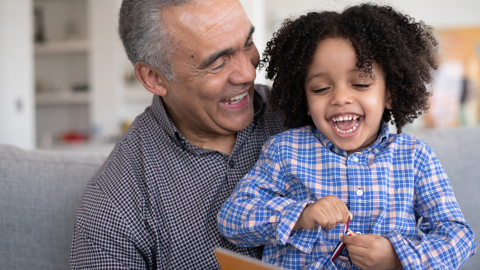 An adult and a child sitting together, engaging with a book