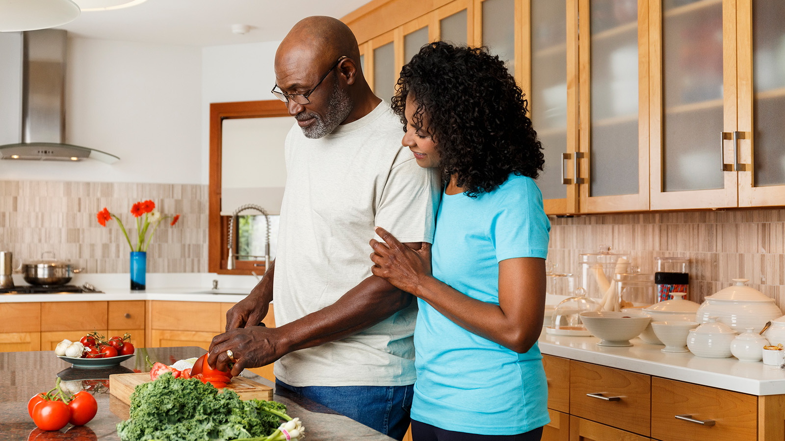 A couple preparing food together in a kitchen