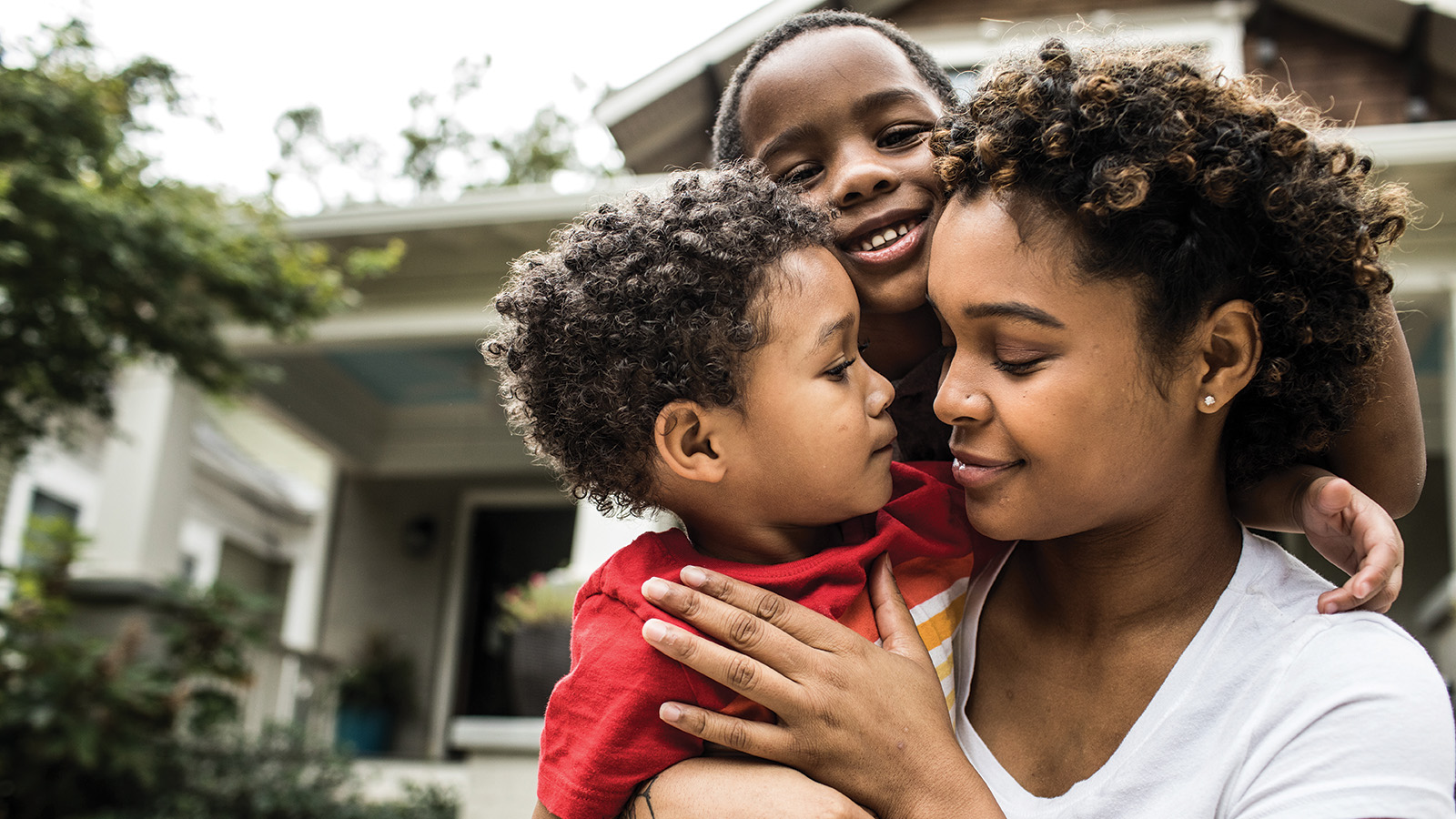 A woman and child enjoying time together outside a house