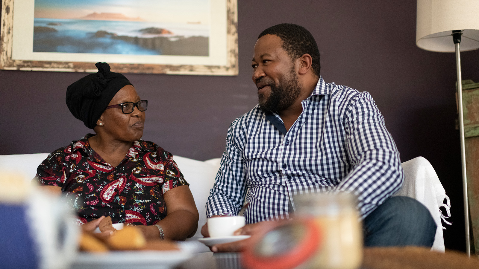 Two people sitting on a couch, engaged in conversation
