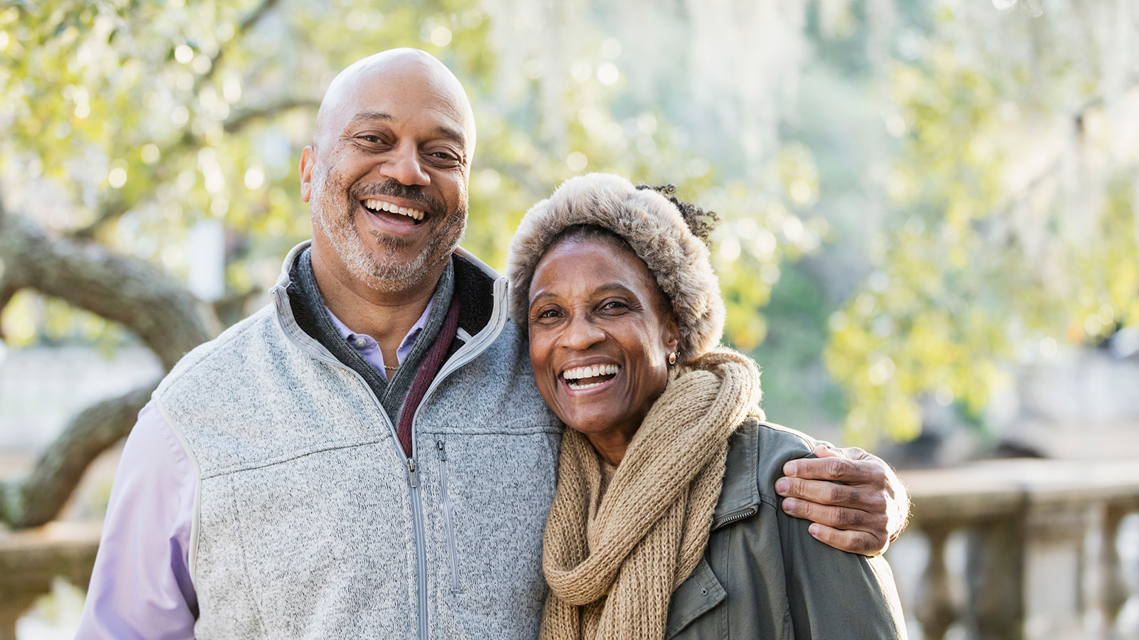 A couple posing together outdoors with a warm smile