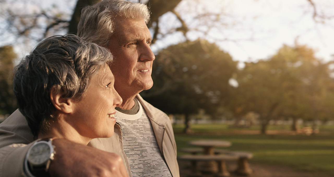 A couple walking closely together in a park